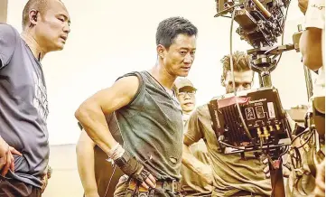  ??  ?? Actor-director Wu Jing (centre) during the filming of ‘ Wolf Warriors 2’.