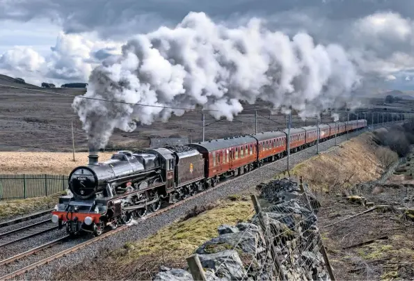  ?? JOHN COOPER‑SMITH ?? You can almost hear the threecylin­der roar as Leander thunders up Shap with the northbound ‘Cumbrian Coast Express’ on March 24 2018. Its current BR lined black livery was applied to some ‘Jubilees’ after nationalis­ation. “I did want it green,” admits Chris Beet, “but now we’ve had it black,
I like it.”