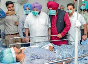  ?? PTI ?? Punjab Chief Minister Capt amarinder Singh and Punjab Minister Navjot Singh Sidhu visit a victim of the train accident at Jodh Phatak, at Civil Hospital in amritsar, on Saturday. —
