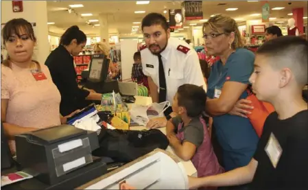  ?? WILLIAM ROLLER PHOTO ?? Lt. John Acosta (third from left), Salvation Army pastor, who helped organize the back-to-school shopping spree at JCPenney on Tuesday in El Centro.