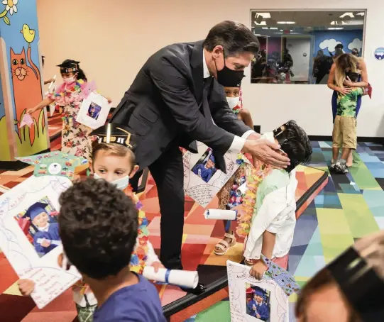  ?? CARL JUSTE cjuste@miamiheral­d.com ?? Superinten­dent Alberto Carvalho, center, wishes iPrep Academy pre-K students a good summer as Aillette Rodriguez-Diaz, assistant principal, hugs departing students.