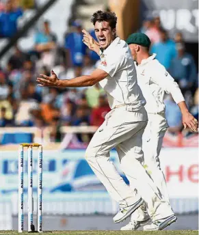  ??  ?? Great joy: Australian bowler Pat Cummins celebrates after he dismissed Indian batsman Ravichandr­an Ashwin on the third day of the third Test match in Ranchi yesterday. — AFP