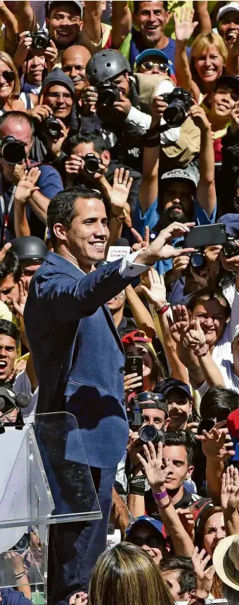  ?? Federico Parra/AFP ?? Juan Guaidó bate selfie em meio a multidão de manifestan­tes, em Caracas