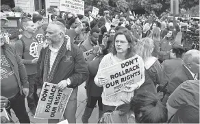  ??  ?? Protesters on both sides gather outside the Supreme Court as justices heard arguments in a landmark employment discrimina­tion case.