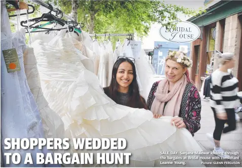  ?? Picture: GLENN FERGUSON ?? SALE DAY: Sanjana Malewar looking through the bargains at Bridal House with consultant Leanne Young.