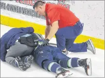  ?? JASON SIMMONDS/JOURNAL PIONEER ?? Summerside Western Capitals head trainer John Blanchard assists with an injured St. Stephen Aces’ player during a recent MHL (Maritime Junior Hockey League) game at Eastlink Arena.