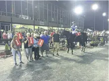  ?? SUBMITTED PHOTO ?? Lets Leavem, ridden by owner Sarah Town and held by trainer Shane Arsenault, as seen in the Kawartah Downs winner's circle following their Race Uner Saddle victory Saturday night.