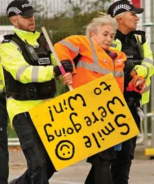  ??  ?? Flashpoint: A protester is restrained at the Cuadrilla site