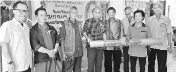  ??  ?? Masir (fourth left) receives a memento from a representa­tive of Rumah Wang women’s bureau. Also seen (from left) are Nelson, Riji, Tuai Rumah Mang and Nelson Lai.