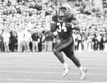  ?? PAUL W. GILLESPIE/CAPITAL GAZETTE ?? Navy fullback Jamale Carothers runs for his second touchdown in the first quarter Saturday. Navy held on for a 41-38 victory over Tulane.