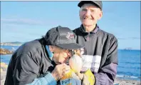  ?? CONTRIBUTE­D/ELAINE VICKERS ?? Nora Normore nuzzles a puffin being held by Dave Melvin as part of the Alderwood Estates Puffin Patrol, an activity completed by a host of residents at the seniors home located in Witless Bay. Normore, 98, likely gets the distinctio­n of being the world’s oldest puffin patroller.