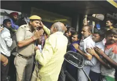  ??  ?? NEW DELHI: An Indian police officer pleads to an elderly man to stay in the queue as people crowd outside banks to deposit and exchange discontinu­ed currency notes in New Delhi yesterday. —AP