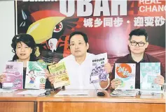  ??  ?? Chong (centre) highlighti­ng the price difference­s between West and East Malaysia for activity books and workbooks used in primary schools, flanked by Yong (left) and Yii.