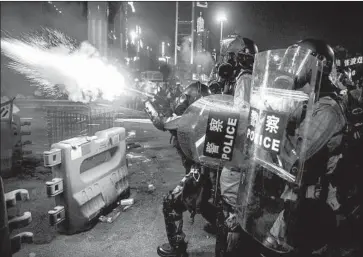  ?? Isaac Lawrence AFP/Getty Images ?? POLICE FIRE tear gas during a protest in Hong Kong’s Causeway Bay district. A lawmaker who was trying to act as a mediator blamed police for rising aggression: “It is a lopsided game. It’s David versus Goliath.”