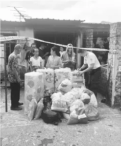  ??  ?? Wan (right) and his staff on site handing over items to the fire victims in Samariang.