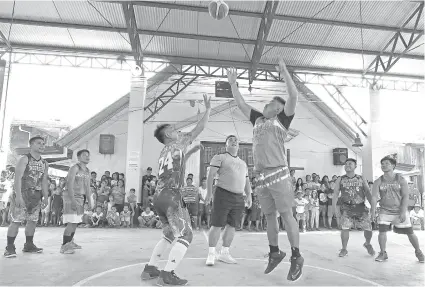  ?? / ALEX BADAYOS ?? ■ LIGA SA BASKETBALL: Si Police Regional Office (PRO) 7 Regional Director Chief Supt. Debold Sinas (tunga) mi-toss sa bola sa pagsugod sa Team PRO7 Basketball League sa Tanke, dakbayan sa Talisay. Tumong ni Sinas mao ang pagpalambo sa maayong relasyon tali sa kapulisan ug komunidad, labina niadtong mga drug surrendere­r ug mahilayo ang kabatan-unan sa drugs.