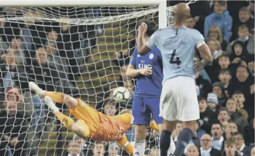  ??  ?? 0 Vincent Kompany watches his shot beat Leicester keeper Kasper Schmeichel to put Manchester City back on top of the Premier League.