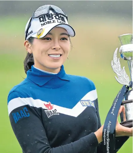  ?? Pictures: Getty/PA. ?? Above: Champion Mi Jung Hur with the trophy after her fourstroke victory at a sodden Renaissanc­e. Above right: Carly Booth flew the flag as highest-finishing Scot.