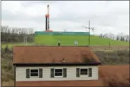  ?? MICHAEL RUBINKAM — THE ASSOCIATED PRESS FILE ?? A shale gas drilling rig, background, rises above a private home, foreground, in the Washington County city of Washington, Pa. Natural gas prices have recovered from 20-year lows, nearly doubling since last year.