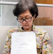  ??  ?? Seeking justice: Ng showing documents regarding the loss of her money.