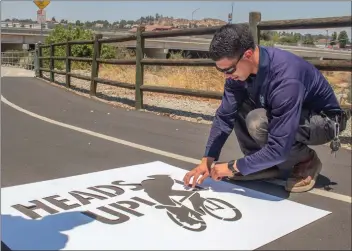  ?? Michele Lutes/The Signal (See additional photos on signalscv.com) ?? (Above) The city of Santa Clarita is adding a new safety effort to its bike trails this week — the “Heads Up” stenciling (below) is meant to encourage cyclists and pedestrian­s to be more conscious of others.