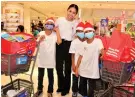  ?? ?? Gladys Cruz-Villanueva with the kids who filled their shopping bags with treats.