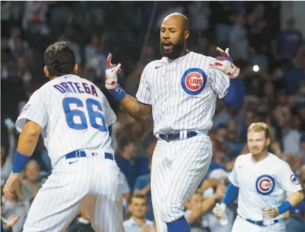  ?? ARMANDO L. SANCHEZ/CHICAGO TRIBUNE ?? Cubs right fielder Jason Heyward, center, celebrates with his team after hitting a three-run, walk-off homer in the 10th inning against the Reds on Sept. 8 at Wrigley Field.