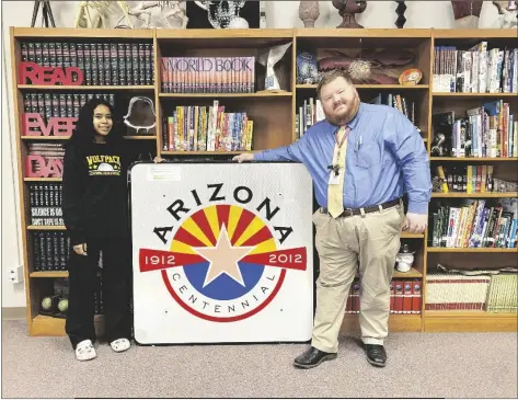  ?? PHOTO BY SISKO J. STARGAZER/YUMA SUN ?? AMELIA BORRALLO (LEFT) AND FRITZ RANDOLPH smile with the authentic Arizona Centennial road sign that will now call Centennial Middle School home.