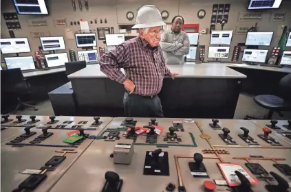  ??  ?? A.C. Cox, 85, talks about some of the changes in technology he saw at the Allen Fossil Plant as he stands over the control panel he used to officially shut down the plant a few weeks ago. Cox began working at the plant just after its completion in...