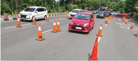  ?? FRIZAL/JAWA POS ?? TAK LAGI PSBB: Lalu lintas kendaraan di Jalan Ahmad Yani dekat bundaran Waru lancar. Meski demikian, traffic cone masih terpasang untuk mengatur laju kendaraan.