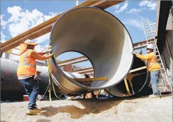  ?? Irfan Khan Los Angeles Times ?? CREWS INSTALL earthquake-resistant iron pipe in San Jacinto. Cyberattac­ks, old infrastruc­ture and outdated software are among the challenges facing drinking water systems in California and across the country.