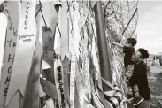  ?? Ahn Young-joon / Associated Press ?? A father holds his son Sunday as he hangs a ribbon wishing for reunificat­ion of the two Koreas on the wire fence in Paju, South Korea.