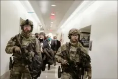  ?? Anna Moneymaker/The New York Times ?? Members of the National Guard walk through the Capitol on Jan. 6 after protesters stormed the building in Washington. Their deployment was delayed by several hours.