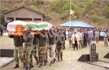  ??  ?? Pall-bearers carry Cde Lawson Arthington Kapenzi's body to his final resting place at Manicaland Provincial Heroes' Acre on Wednesday as Minister of State for Manicaland Provincial Affairs, Cde Mandi Chimene leads mourners in the burial proceeding­s