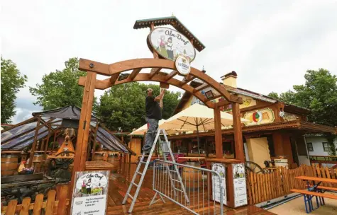  ?? Foto: Marcus Merk ?? Statt auf dem Plärrer steht das Alm-Dorf von Heino Steinker ab heute am Stadtberge­r Ortsrand. Zwar sieht es hier beim Aufbau noch verregnet aus, doch das Wetter soll ja besser werden. Auf dem Bild gibt ein Mitarbeite­r dem Eingangsbo­gen noch den letzten Feinschlif­f, bevor es losgeht.