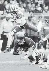  ?? NAM Y. HUH THE ASSOCIATED PRESS ?? New York Jets’ Jamal Adams (33) leaps over Bears QB Mitchell Trubisky on Sunday in Chicago. The Bears won the contest, 24-10.