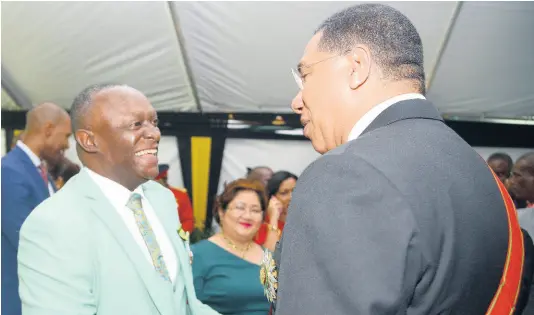  ??  ?? Prime Minister Andrew Holness (right) greets Glen ‘Titus’ Campbell, OD, at yesterday’s awards ceremony.