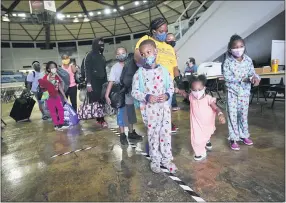  ?? GERALD HERBERT — THE ASSOCIATED PRESS ?? Victoria Nelson with her children Autum Nelson, 2; Shawn Nelson, 7; and Asia Nelson, 6, line up to board a bus to leave Lake Charles, La., Wednesday ahead of Hurricane Laura.