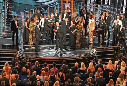  ??  ?? The cast of ‘Moonlight’ and “’La La Land” appear on stage as presenter Warren Beatty (center), flanked by host Jimmy Kimmel (left) shows the winner’s envelope for Best Movie “Moonlight” on stage at the 89th Oscars on February 26, 2017 in Hollywood,...
