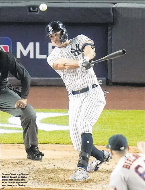  ?? AP ?? Yankees’ Giancarlo Stanton follows through on double during fifth inning, part of his four-hit night in win over Houston at Stadium.