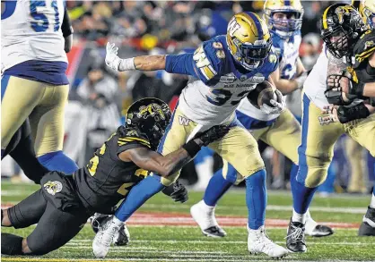  ?? ERIC BOLTE/USA TODAY SPORTS ?? Winnipeg Blue Bombers running back Andrew Harris is tackled by Hamilton Tiger-Cats defensive back Cariel Brooks during the 107th Grey Cup in Calgary on Sunday.