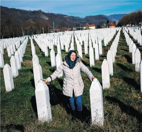  ?? DIMITAR DILKOFF / AFP / GETTY IMAGES ?? A woman mourns over a relative’s grave at the memorial centre of Potocari near Srebrenica in Bosnia and Herzegovin­a.