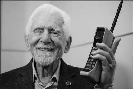  ?? JOAN MATEU PARRA / AP ?? Marty Cooper, the inventor of first commercial mobile phone, poses with a Motorola DYNATAC 8000x Monday during an interview with The Associated Press at the Mobile World Congress 2023 in Barcelona, Spain. Cooper made the first public call from a handheld portable telephone on April 3, 1973, on a New York City street using a prototype device that his team at Motorola had started designing only five months earlier. He famously called his rival at Bell Labs, owned by AT&T.