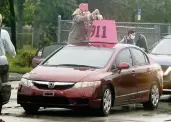  ?? CHARLES TRAINOR JR ctrainor@miamiheral­d.com ?? Retired teacher Chris Kirchner prepares her car as she joins a caravan of cars to drive to the Miami-Dade School Board.