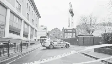  ??  ?? A police car parked in a closed area after a constructi­on crane was bent overnight in high winds brought by Storm Katie in south London. — AFP photo