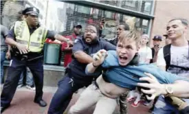  ?? — AP ?? BOSTON: A counter-protester, part of a small group who remained on the street hours after a “Free Speech” rally was staged by conservati­ve activists, scuffles with a security guard and police.