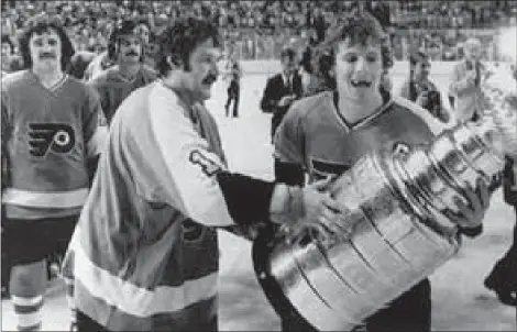  ?? THE ASSOCIATED PRESS ?? Bobby Clarke, right, and Bernie Parent of the Philadelph­ia Flyers carry the Stanley Cup off the ice in Buffalo, N.Y., on May 28, 1975. The Flyers beat the Buffalo Sabres 2-0to win their second consecutiv­e NHL Stanley Cup.
