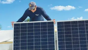  ?? COURTESY ?? An employee of Boca Raton-based Go Solar Power works on a solar panel installati­on on the roof of a home. Solar experts caution homeowners not to install solar panels on roofs that will need to be replaced within 10 years. Removing and reinstalli­ng the panels can be very expensive, they say.