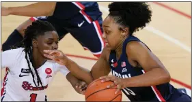 ?? (AP/Kathy Willens) ?? Connecticu­t guard Christyn Williams (right) drives toward the basket against St. John’s guard Unique Drake during the top-ranked Huskies’ victory Wednesday night in New York.