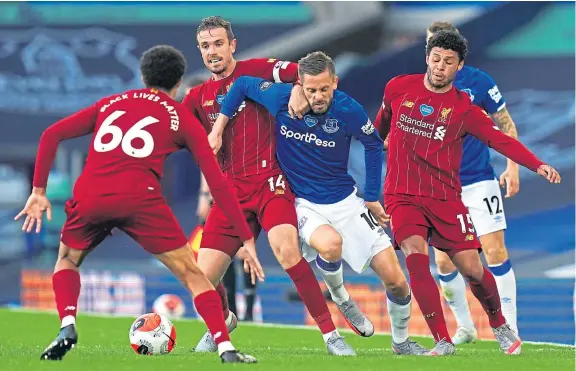  ?? Picture: PA. ?? Everton’s Gylfi Sigurdsson, centre right, and Liverpool captain Jordan Henderson battle for the ball.